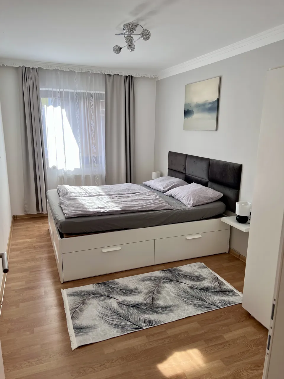 Doppelbett und Teppich im Schlafzimmer von Apartment 2