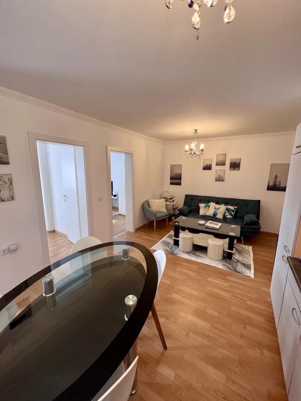 Wohn- und Essbereich von Apartment 2 mit Sofa und Glastisch
